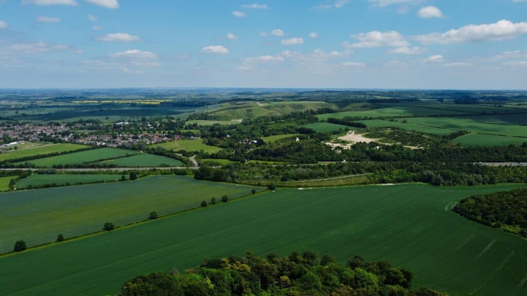 Aerial shot of lush green fields and rolling hills in Central Bedfordshire, England.